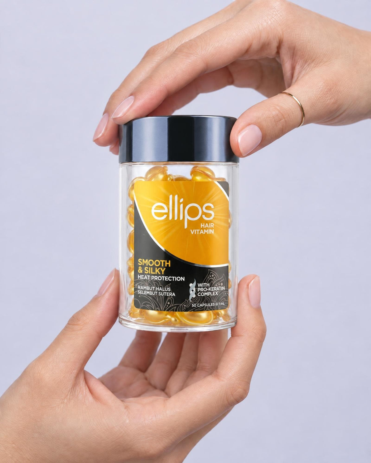 Två händer som håller en burk Ellips Smooth & Silky