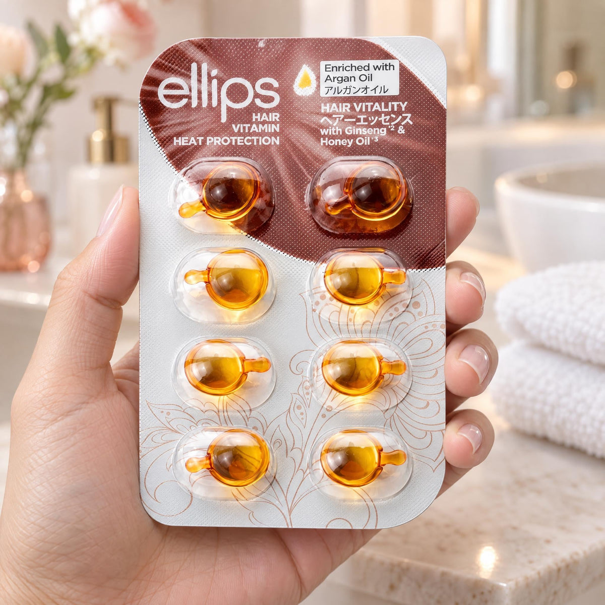 En hand som håller Ellips Hair Vitality i provstorlek med 8 kapslar