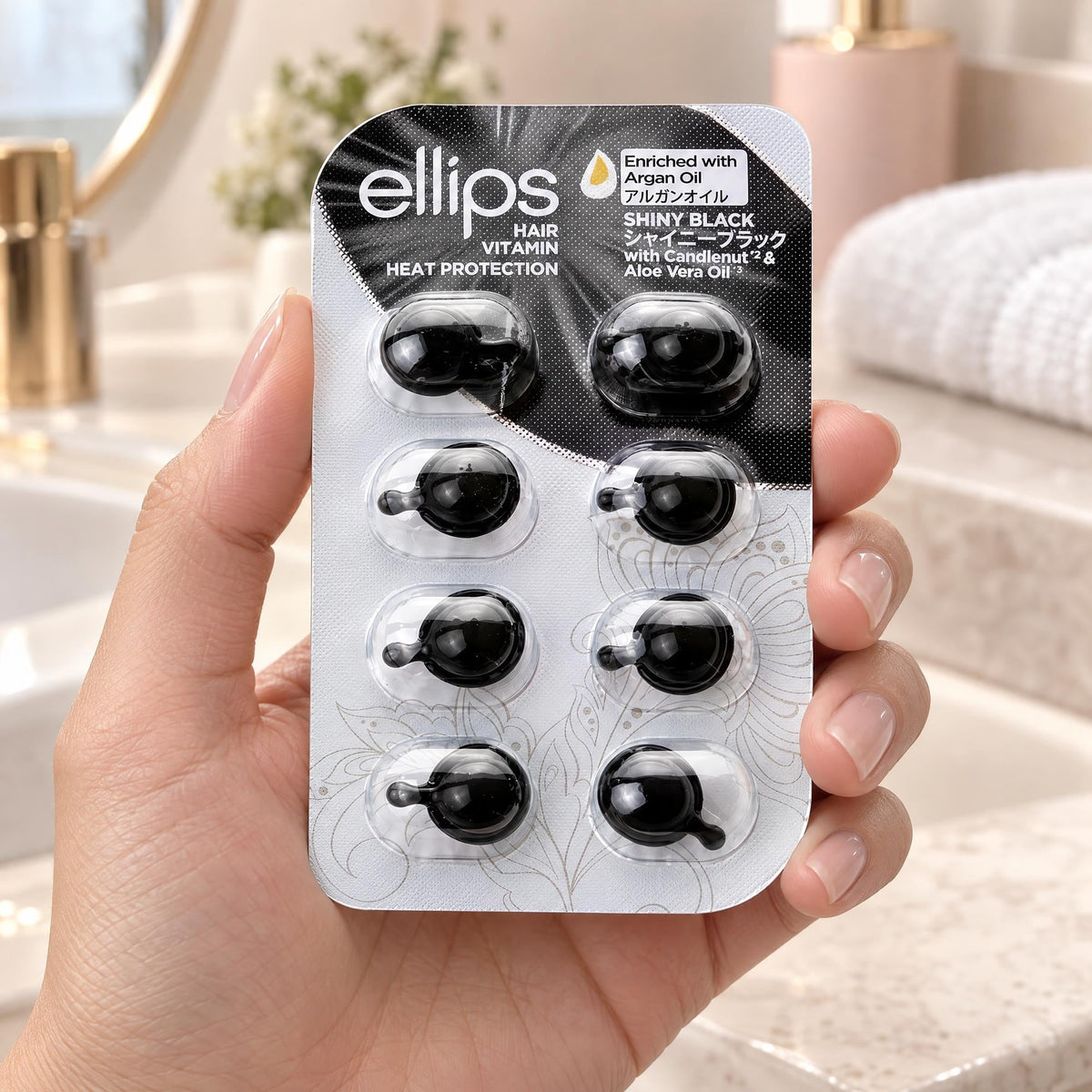 En hand som håller Ellips Shiny Black i provstorlek med 8 kapslar