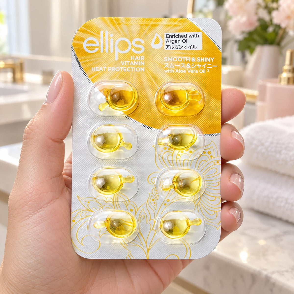En hand som håller Ellips Smooth & Shiny i provstorlek med 8 kapslar