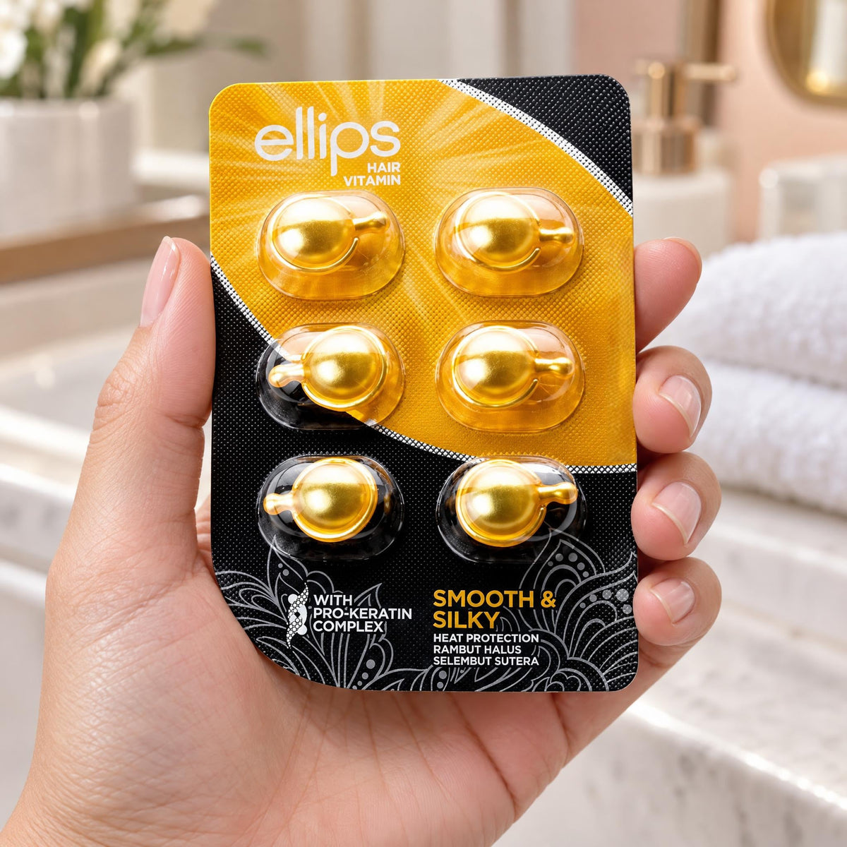 En hand som håller Ellips Smooth & Silky i provstorlek med 6 kapslar
